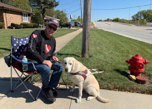 Longtime South Holland resident Rick Olson waited with his dog Pretzel to show his respects at 170th St. and Kimbark Ave. in South Holland. Olson is a recreational diver, which made him want to support the Cunningham family and South Holland Fire Department even more. (Photo: Josh Bootsma)