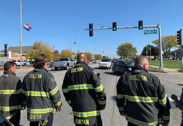 A group of Dolton firefighters stood in respect as the procession turned from Highway 6 onto Wausau Ave. in South Holland. (Photo: Josh Bootsma)