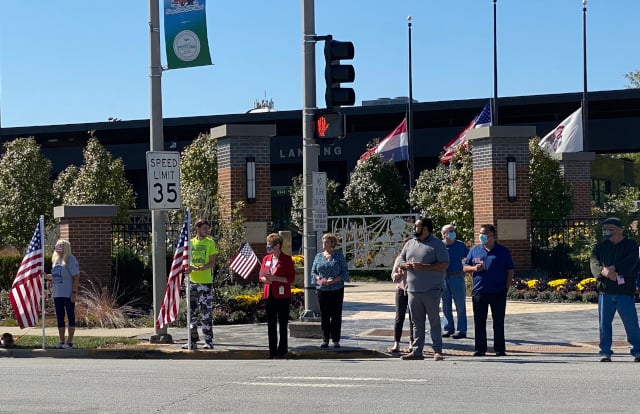 Mayor Eidam (center, in red) and other Village officials stood on the side of Burnham Ave. to honor Dylan Cunningham as his procession passed by. (Photo: Melanie Jongsma)